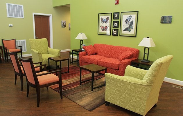 Living room with couch, chairs and tables.