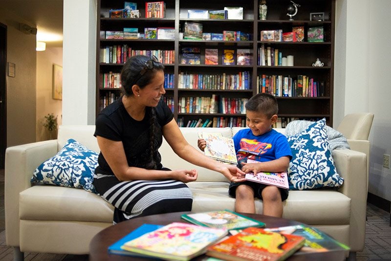 Mom and Son reading a book together in a library room