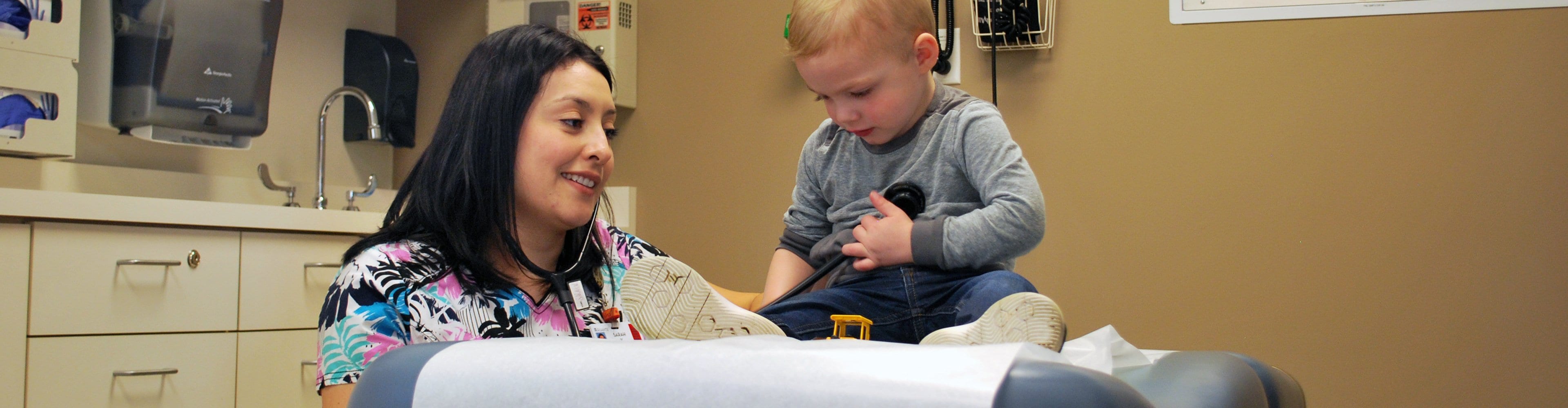 Nurse checking a toddler's heart beat