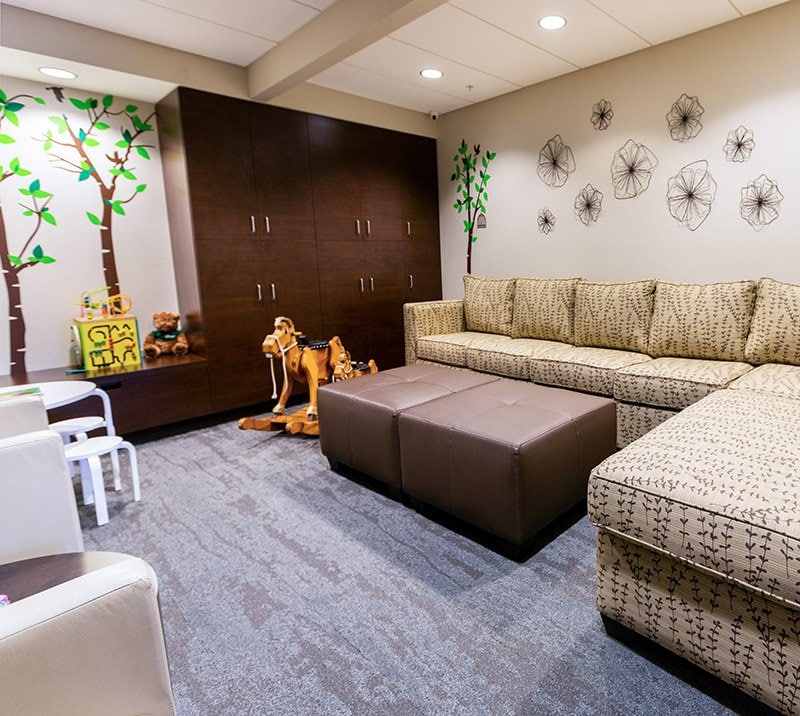 Recreation Room with a couch, toys and reading table for kids.