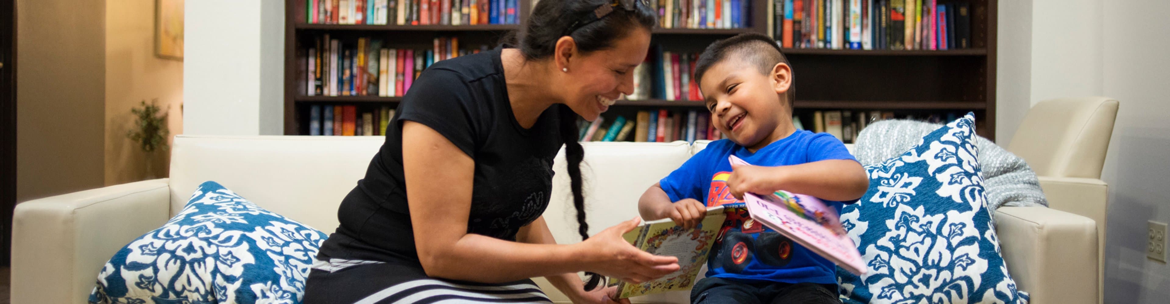 Smiling mother and son reading a book together